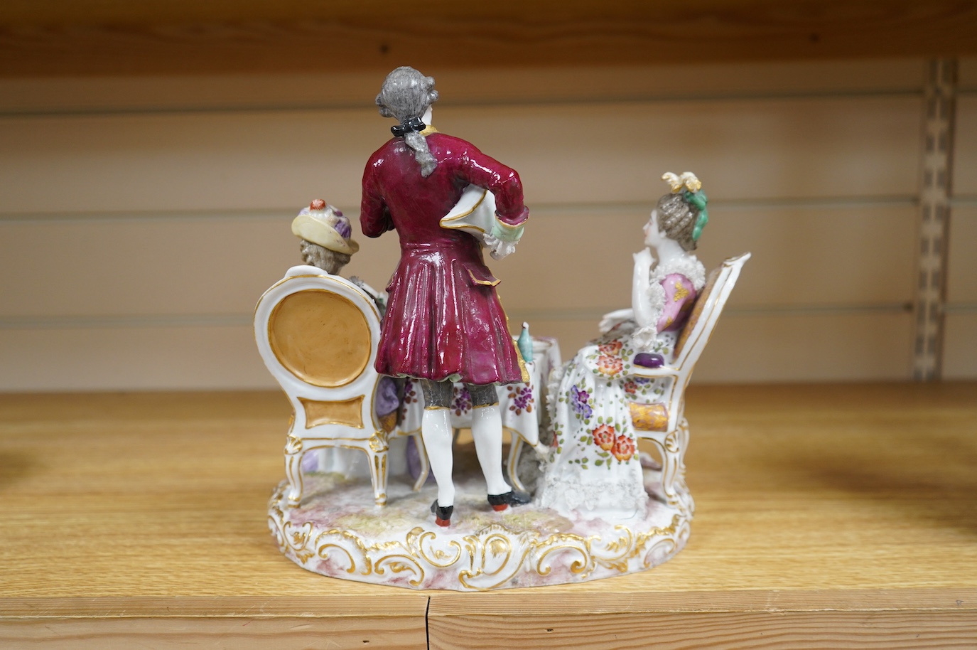 A large German porcelain ‘Tea Party’ group, 25cm high. Condition - has broken and been re-glued